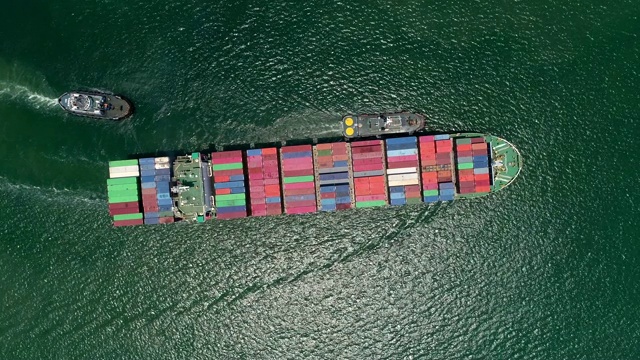 4K分辨率特写:航拍俯视图拖船拖集装箱船满载集装箱前往港口或集装箱仓库进行物流、航运、进出口或运输。视频素材