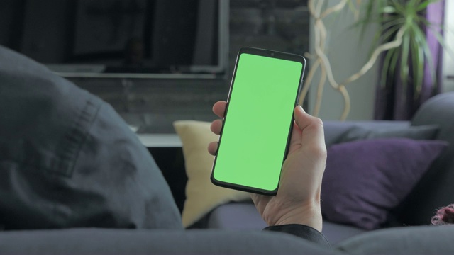 绿屏-拿着智能手机的人。越过肩景。视频素材