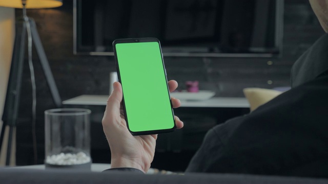 绿屏-拿着智能手机的人。越过肩景。视频素材