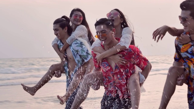 暑假的热带海滩上，快乐的男友们背着他们的女朋友一起欢笑。假期——iStock视频下载