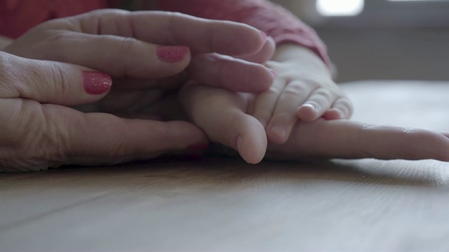 年长成熟的女人和小女孩的手的特写。视频素材
