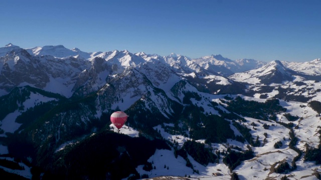 令人惊叹的近距离鸟瞰瑞士中部白雪覆盖的高山山峰。这是在极端地形上方的热气球上拍摄的。视频素材