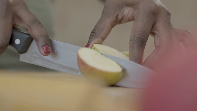 非裔美国妇女用刀在木板上切美味多汁的苹果视频素材