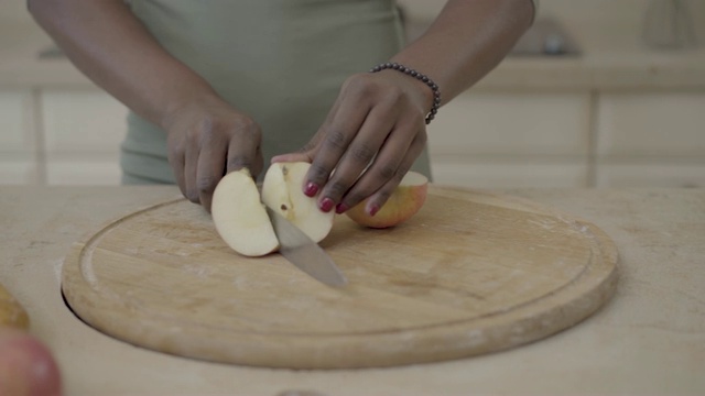 非裔美国妇女用刀在木板上切苹果视频素材