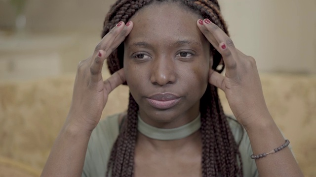 肖像紧张的非洲裔美国妇女与发辫按摩她的头与手指。视频素材