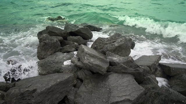 自然背景。汹涌的海浪拍打着海岸的岩石，慢镜头视频素材