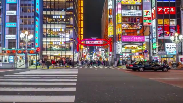 4K时间推移-放大人群穿过斑马线进入购物区与光背景新宿地区-日本东京视频素材