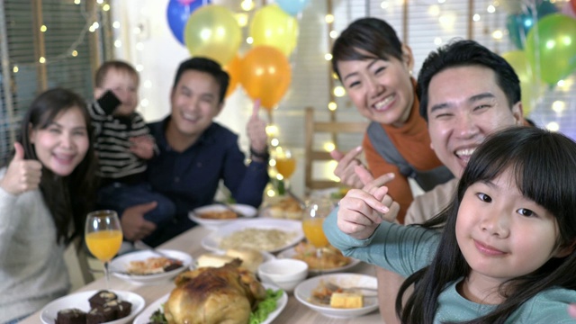亚洲人一起吃饭，用智能手机拍照。幸福的家庭成员时间和享受在家吃饭。节日的概念，新年和生日快乐。视频下载