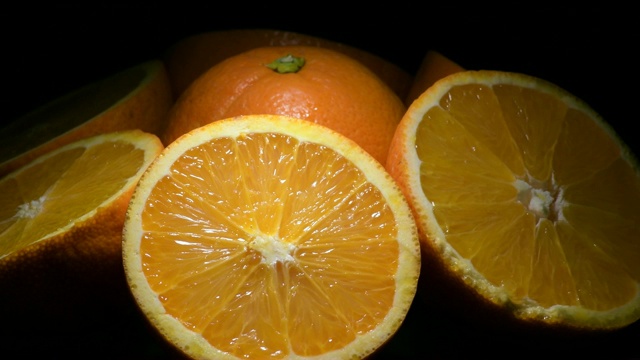 新鲜的橙子水果切割旋转与黑色背景视频素材
