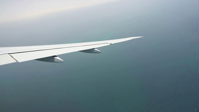 从机翼上的飞机窗口观看。客机。飞机从海上飞过视频素材