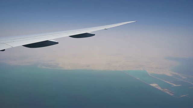 飞机从海水上飞过。从窗口可以看到海岸线。航空运输及旅游视频素材