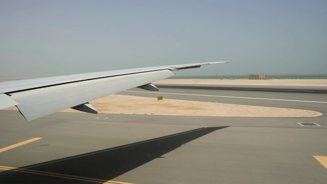飞机在跑道上着陆。大机翼上的窗户和地平线上的海洋视频素材