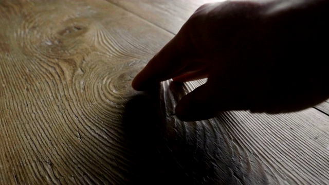 一只手触摸一件木制家具的特写镜头，以感受它的一致性和它所建造的珍贵材料。视频素材