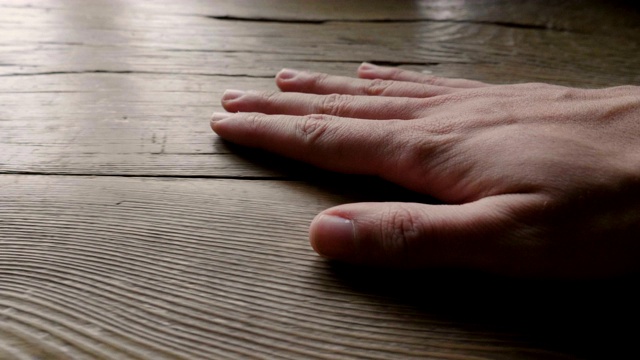 一只手触摸一件木制家具的特写镜头，以感受它的一致性和它所建造的珍贵材料。视频素材