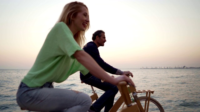 微笑的朋友在海边骑车视频素材