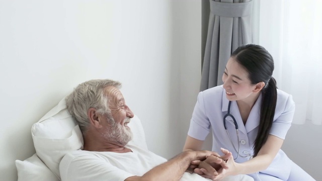 爷爷或老人躺在床上，护士来到老人身边，微笑着做健康检查和讨论视频素材