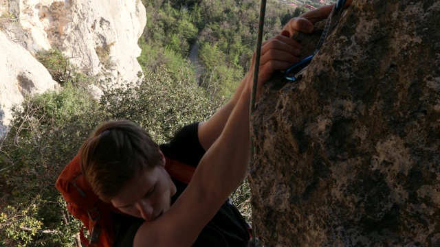 雄性攀登者从下面的森林爬上陡峭的岩洞视频下载