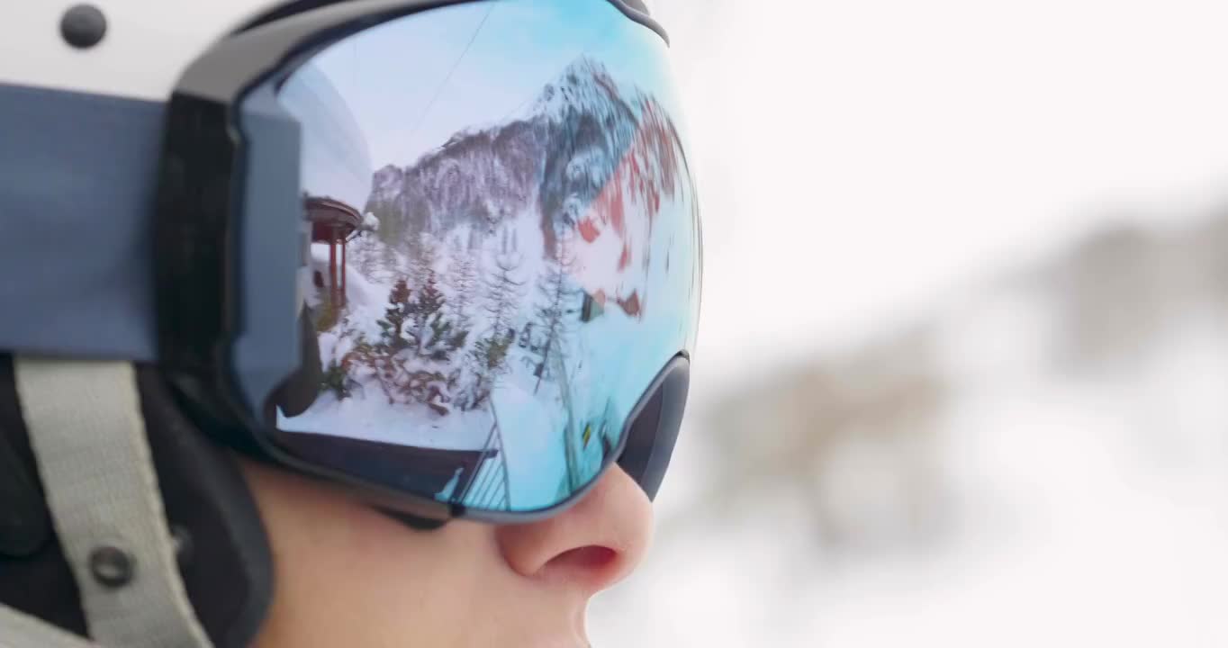 一个微笑的滑雪者在山上度假的肖像，在她的身后你可以看到白雪覆盖的山。视频购买
