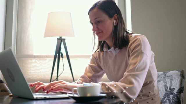 在笔记本电脑上工作的女性会因为一条短信而分心视频素材