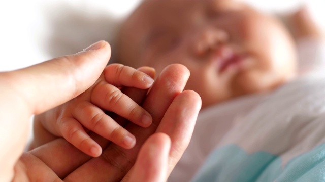 新生婴儿的手指牵着妈妈的手视频素材