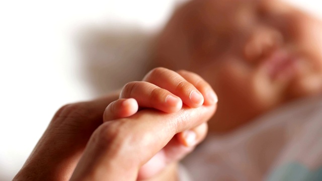 新生婴儿的手指牵着妈妈的手视频素材