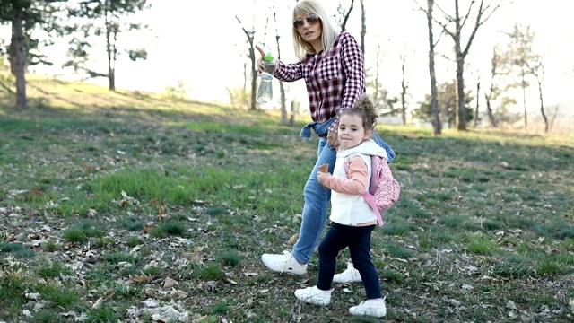 在春天的一天，妈妈和女儿在公园散步视频素材