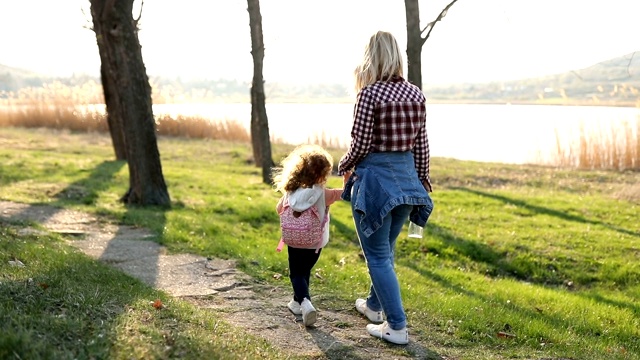 在春天的一天，妈妈和女儿在公园散步视频素材