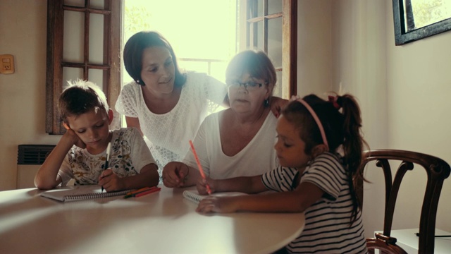 母亲和祖母花时间陪孩子们画画(慢动作)视频素材