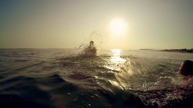 年轻人跑酷后空翻从父亲的肩膀在海上日落，慢动作视频素材