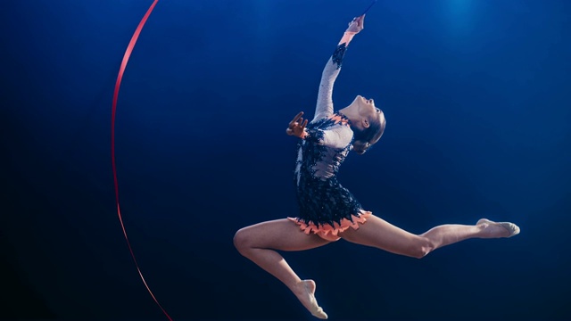 SLO MO艺术体操运动员用她的丝带做一个大的圈，做一个雄鹿跳跃视频素材