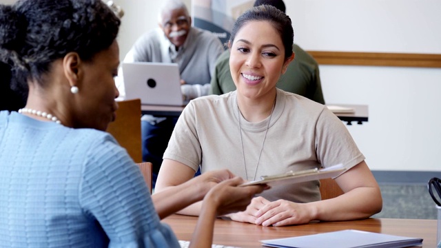 成熟的非裔美国女性银行信贷员协助女兵申请贷款视频素材