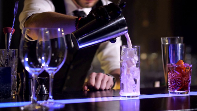 调酒师将调制好的鸡尾酒倒入玻璃杯中视频下载