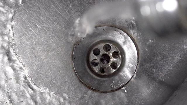 水滴从水龙头滴落到厨房的水槽，电影背景循环视频素材