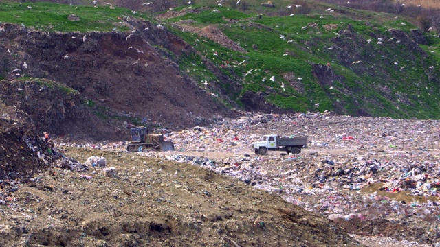 拖拉机和卡车停在一个大型有毒垃圾场视频素材
