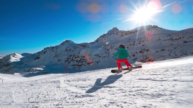SLO MO TS女性滑雪板在阳光下骑下白雪覆盖的山坡视频素材