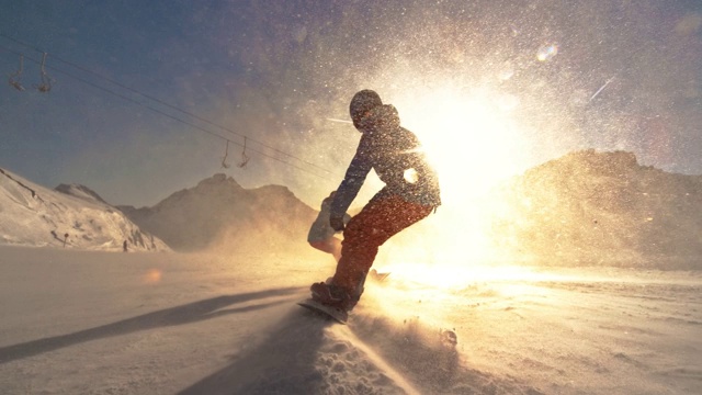 速度坡道两名滑雪板运动员朝着夕阳滑行视频下载