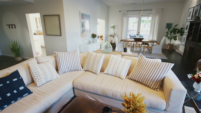 一个舒适的家庭客厅，白色的墙壁和深色的木地板，手持视频下载
