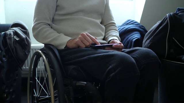 中年残疾成熟商人在酒店房间使用手机视频素材