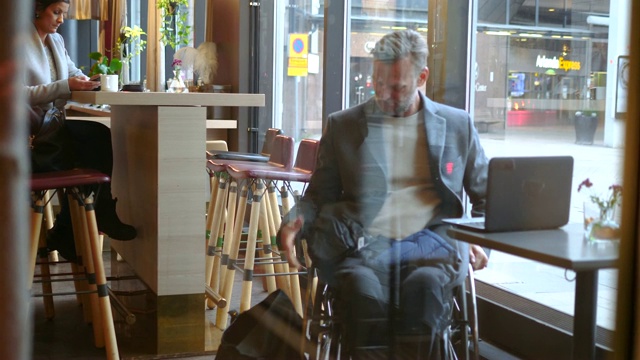 成熟的残疾商人在饭店餐厅脱大衣视频素材