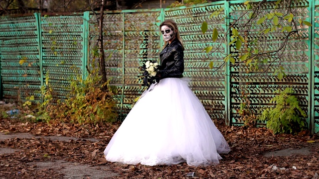 在一个旧篱笆的背景上，化妆成骷髅的恐怖新娘。视频素材