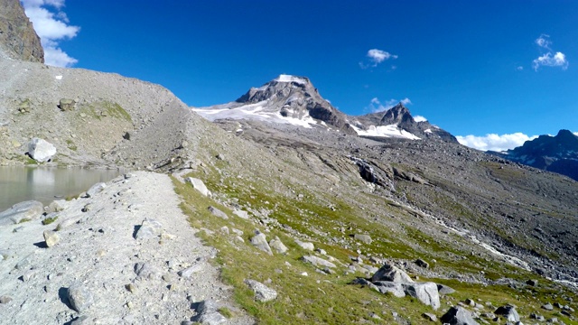 维托里奥·埃马努埃莱二世避难所小屋附近的山湖和山脉的全景，探险到意大利阿尔卑斯山的大帕拉迪索山顶视频素材