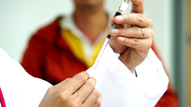医生用注射器从药瓶中吸药治疗病人视频素材