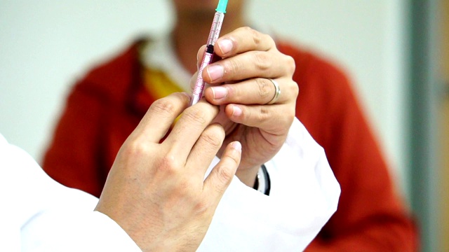 医生用注射器从药瓶中吸药治疗病人视频素材
