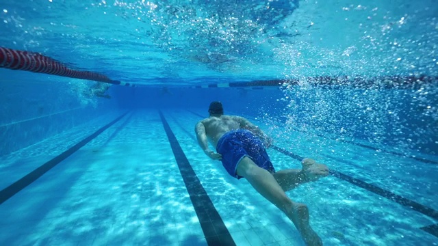 强壮的运动员在清澈的水疗池中游泳视频素材