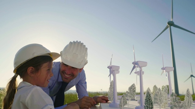 一位工程师父亲向女儿展示他的建设风电场的计划。女儿对可再生能源感兴趣。视频素材