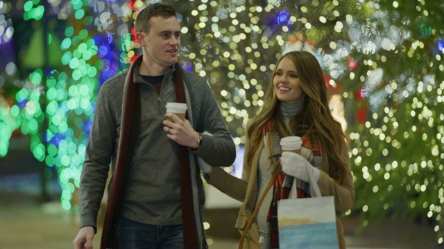 美国犹他州的普罗沃，一对夫妇在圣诞节期间拎着购物袋在户外逛街视频素材