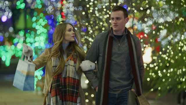 美国犹他州普罗沃，一对夫妇在圣诞节外出散步，然后一名女子说服一名男子进入一家零售店视频素材