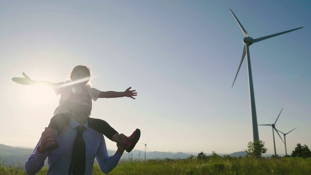 一位工程师父亲，将女儿抱在怀里，在风力涡轮机之间自由奔跑。视频下载