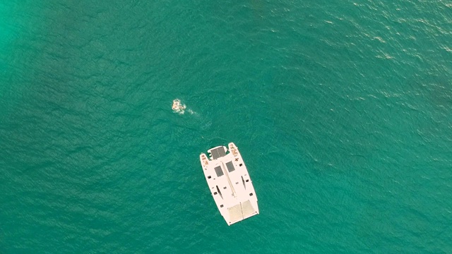 蓝绿色泻湖上的双体船巡游。鸟瞰图视频下载