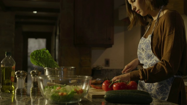 在美国犹他州的雪松山，一位妇女正在厨房为沙拉切西红柿视频素材